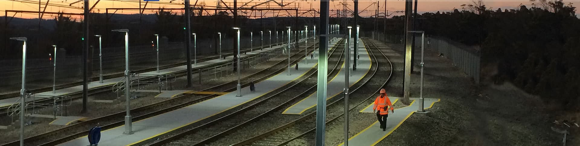 A Franklins crew member walking a rail corridor at dusk